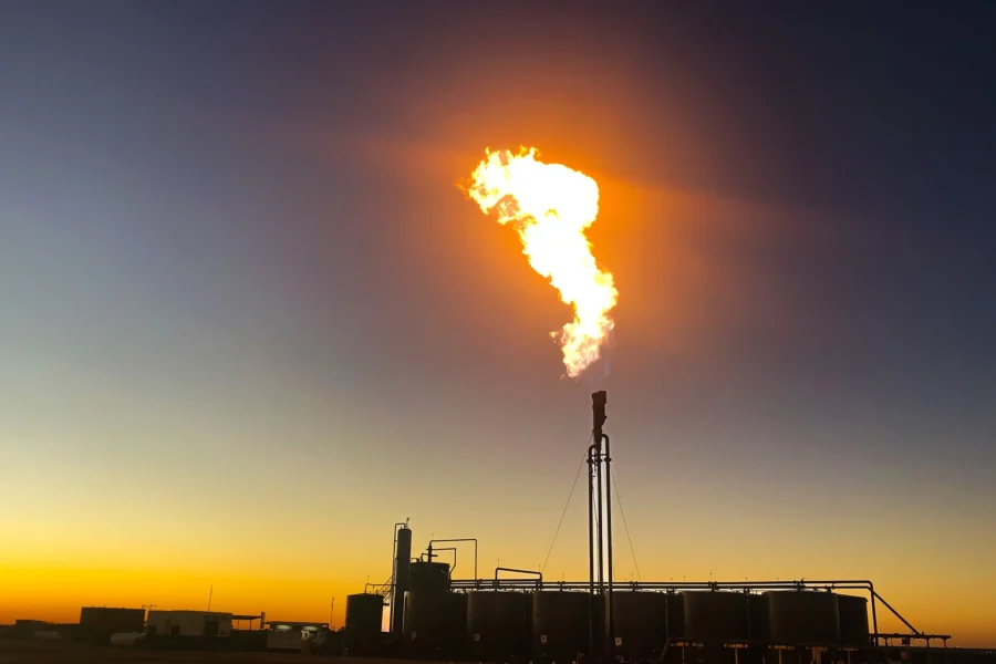 Gas flaring at an oilfield facility at sunset